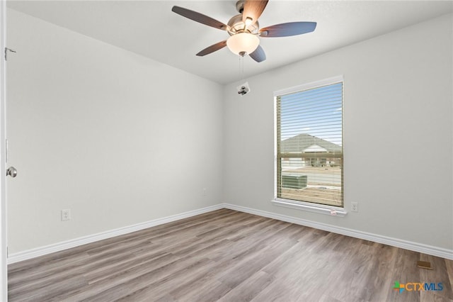 unfurnished room with baseboards, ceiling fan, and light wood finished floors