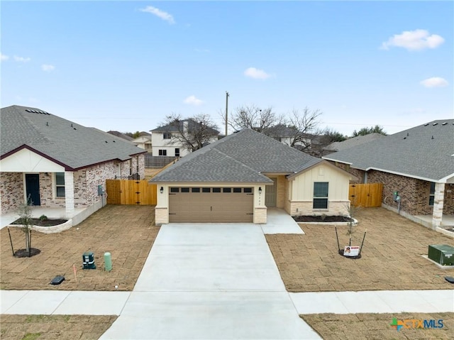 view of front facade with roof with shingles, concrete driveway, central AC, a garage, and a residential view