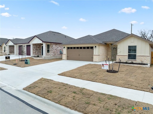 ranch-style house featuring an attached garage, brick siding, concrete driveway, roof with shingles, and board and batten siding