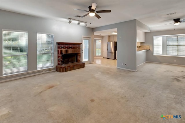 218 Sunset Dr, Victoria, TX 77901 - unfurnished living room featuring a ceiling fan, light carpet, track lighting, and a fireplace