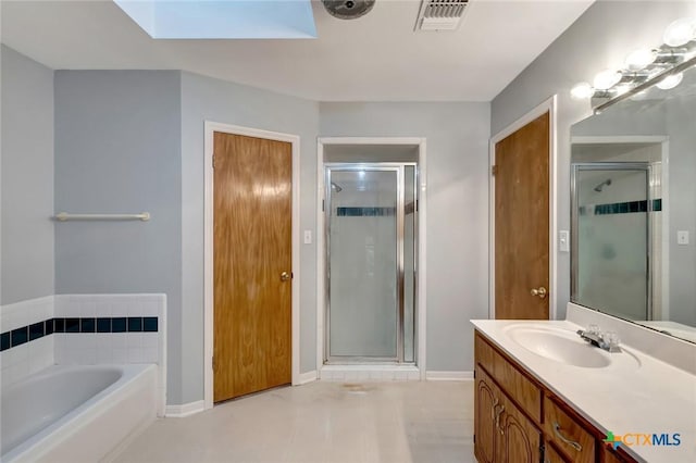 218 Sunset Dr, Victoria, TX 77901 - bathroom featuring a skylight, a shower stall, and vanity