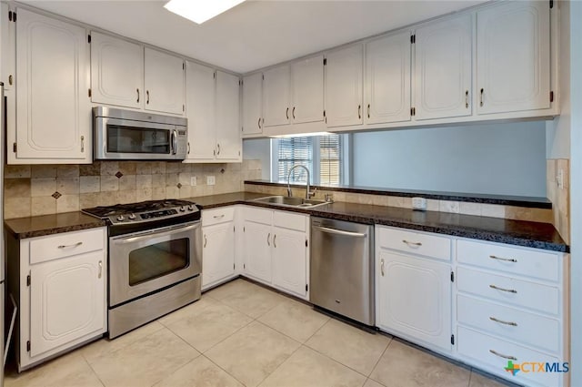 218 Sunset Dr, Victoria, TX 77901 - kitchen featuring appliances with stainless steel finishes, decorative backsplash, light tile patterned floors, and white cabinetry