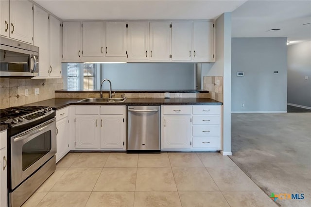 218 Sunset Dr, Victoria, TX 77901 - kitchen featuring stainless steel appliances, dark countertops, decorative backsplash, and white cabinets