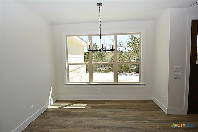 1598 Desiree St, Canyon Lake, TX 78133 - unfurnished dining area with a chandelier, baseboards, and dark wood-style flooring
