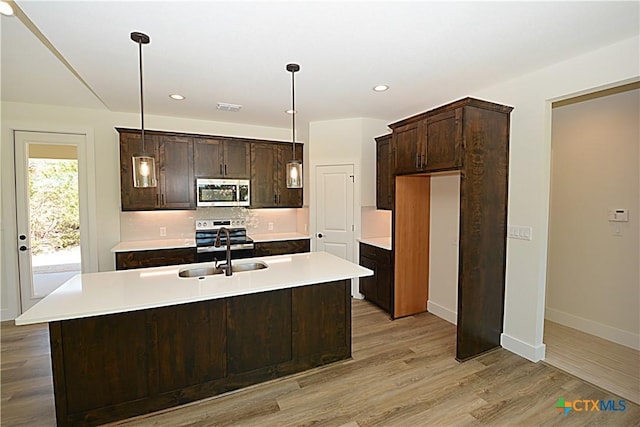 1598 Desiree St, Canyon Lake, TX 78133 - kitchen featuring visible vents, dark brown cabinets, light wood-style flooring, appliances with stainless steel finishes, and a sink