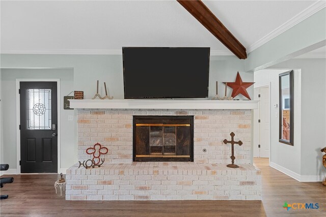 details with ornamental molding, a fireplace, beamed ceiling, and hardwood / wood-style flooring