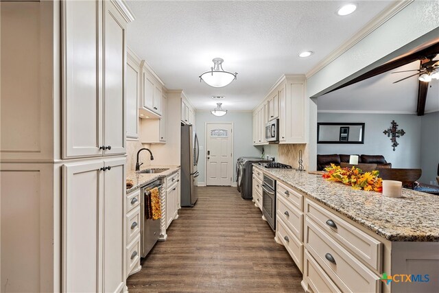 kitchen featuring stainless steel appliances, dark hardwood / wood-style flooring, light stone counters, sink, and white cabinetry