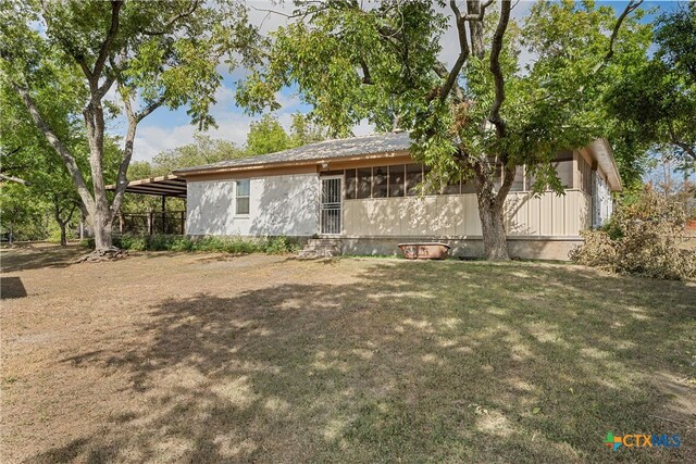 view of property exterior with a lawn and a carport