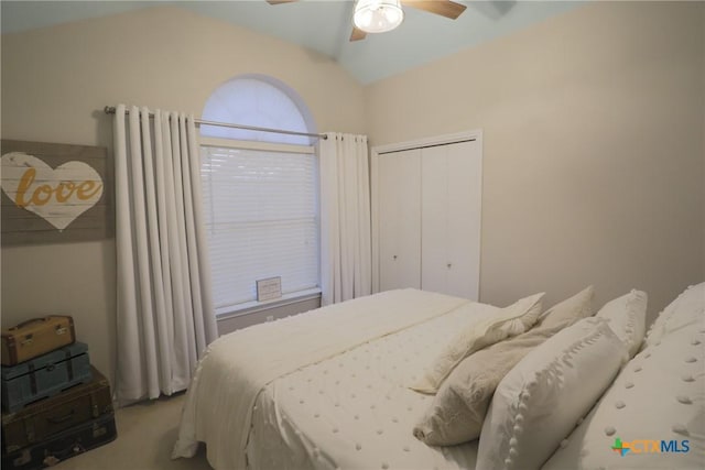 bedroom with a closet, a ceiling fan, carpet, and lofted ceiling