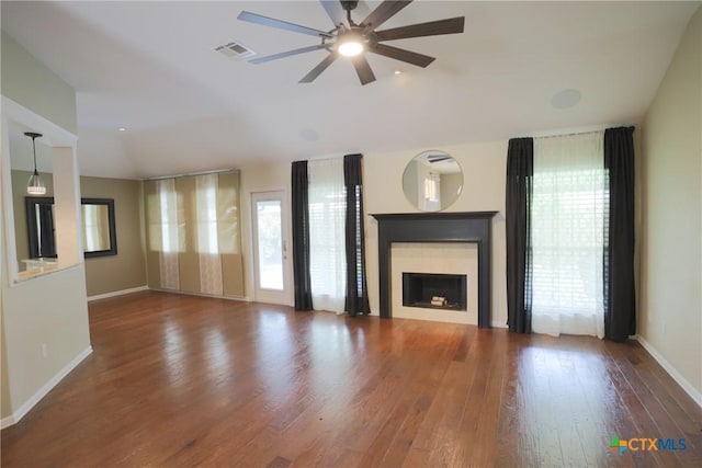 unfurnished living room with a ceiling fan, visible vents, wood finished floors, and a healthy amount of sunlight