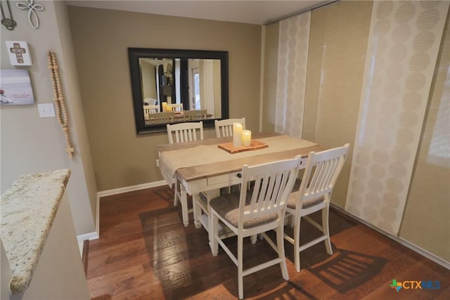 dining room with baseboards and wood finished floors