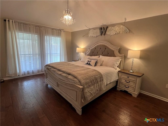 bedroom with a chandelier, dark wood-style floors, and baseboards