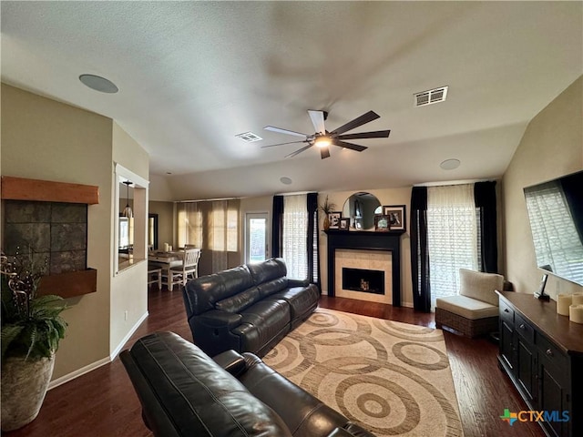 living area featuring visible vents, wood finished floors, ceiling fan, and a fireplace