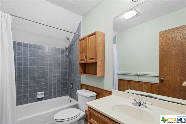 full bathroom featuring toilet, vanity, a textured ceiling, and shower / bathtub combination with curtain