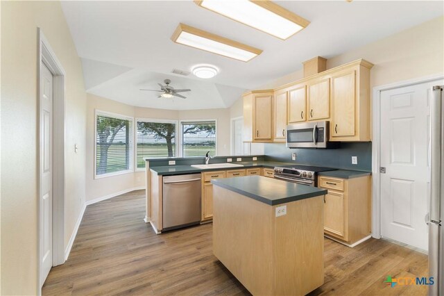 99 N Seakist Ln, Port Lavaca, TX 77979 - kitchen with stainless steel appliances, light brown cabinets, a peninsula, and dark countertops