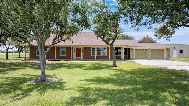 99 N Seakist Ln, Port Lavaca, TX 77979 - ranch-style house with an attached garage, concrete driveway, a front lawn, and covered porch