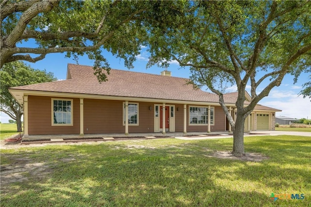 99 N Seakist Ln, Port Lavaca, TX 77979 - ranch-style home with a garage, a front lawn, a chimney, driveway, and covered porch