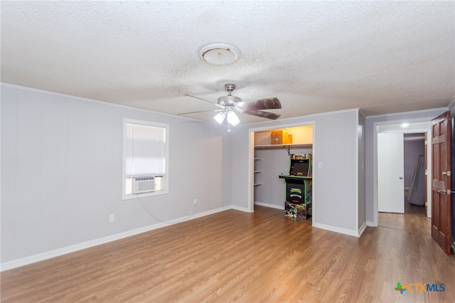 unfurnished living room featuring a textured ceiling, light wood-type flooring, cooling unit, and crown molding