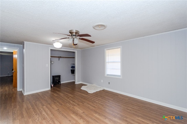 interior space featuring ceiling fan, dark hardwood / wood-style flooring, crown molding, a textured ceiling, and a closet