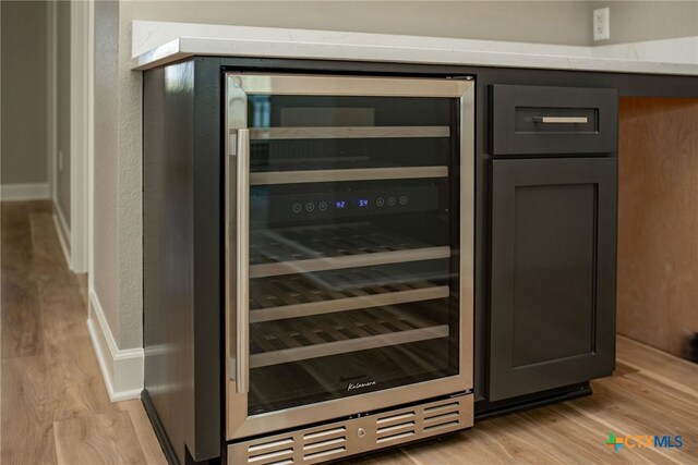 room details featuring light wood-type flooring, gray cabinets, and wine cooler