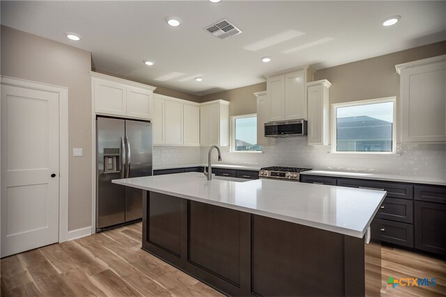 kitchen featuring a wealth of natural light, white cabinetry, appliances with stainless steel finishes, and sink