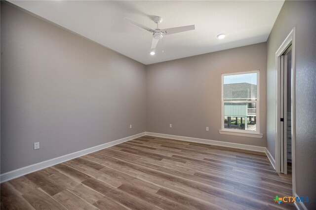 unfurnished room with hardwood / wood-style flooring and ceiling fan