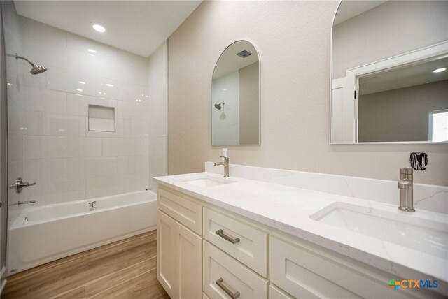 bathroom with vanity, tiled shower / bath, and hardwood / wood-style flooring