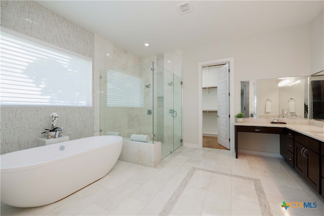 bathroom featuring independent shower and bath, vanity, and tile patterned flooring