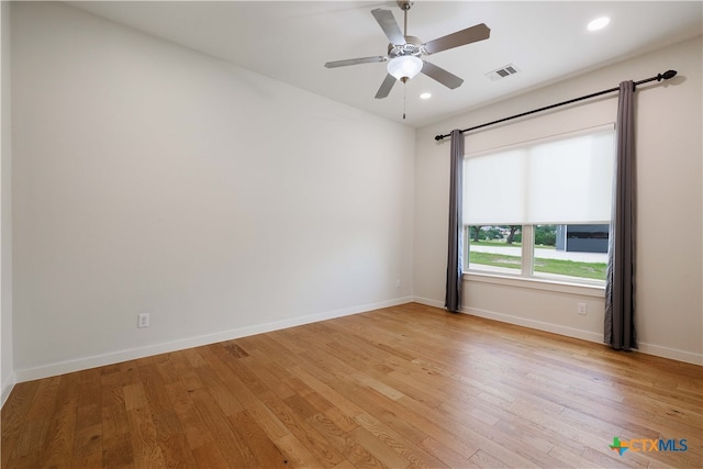 spare room with light wood-type flooring and ceiling fan