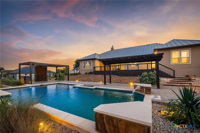 pool at dusk with a gazebo, pool water feature, and a patio area