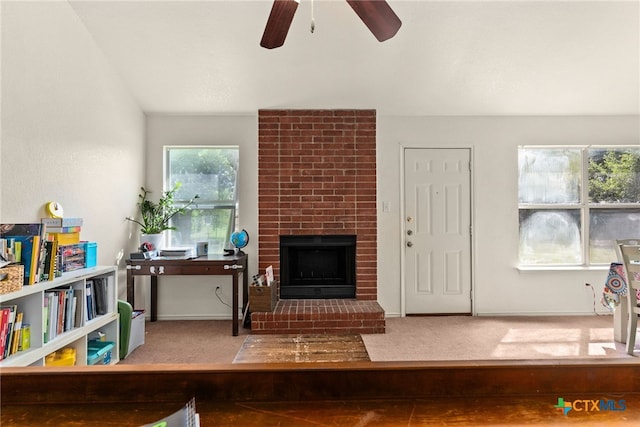 living room featuring a fireplace, carpet floors, ceiling fan, and vaulted ceiling