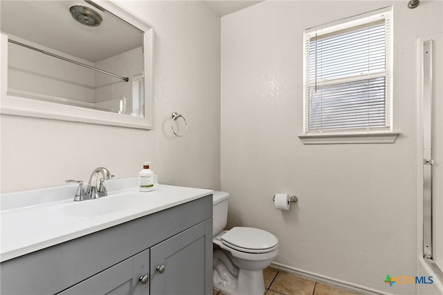 bathroom with toilet, a shower, vanity, and tile patterned floors