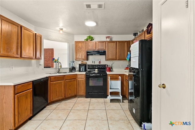 kitchen with light tile patterned floors, a textured ceiling, sink, and black appliances