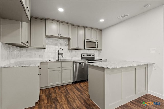 kitchen featuring gray cabinetry, sink, stainless steel appliances, and dark wood-type flooring