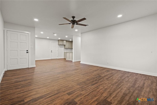 unfurnished living room with ceiling fan and dark wood-type flooring