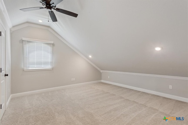 additional living space with vaulted ceiling, light colored carpet, and ceiling fan