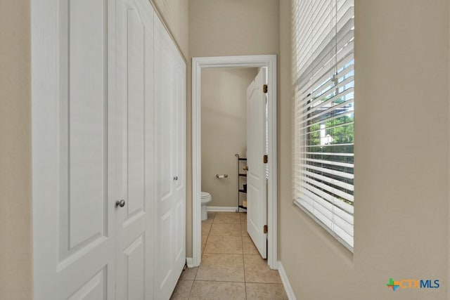 hallway with baseboards and light tile patterned floors