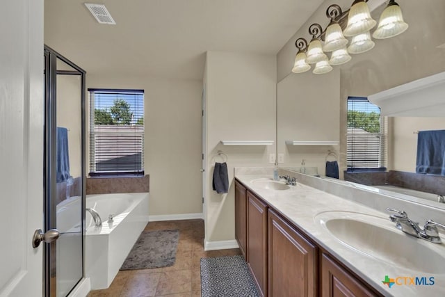 full bathroom with visible vents, a garden tub, double vanity, and a sink