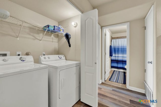washroom featuring independent washer and dryer, visible vents, baseboards, dark wood-style flooring, and laundry area