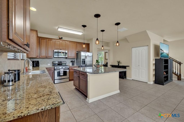 kitchen featuring appliances with stainless steel finishes, light tile patterned floors, decorative backsplash, and a sink