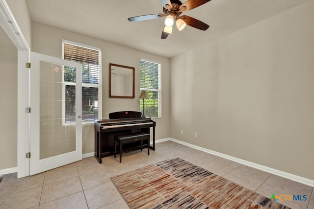 sitting room featuring a ceiling fan, french doors, tile patterned floors, and baseboards