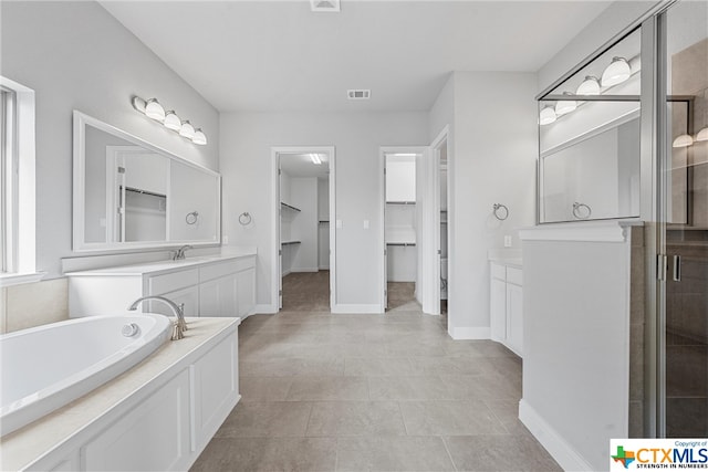 bathroom with independent shower and bath, vanity, and tile patterned floors