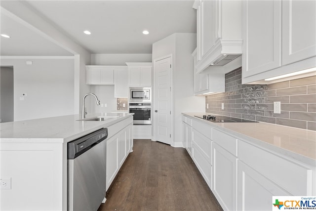 kitchen with light stone counters, white cabinets, sink, dark hardwood / wood-style floors, and appliances with stainless steel finishes