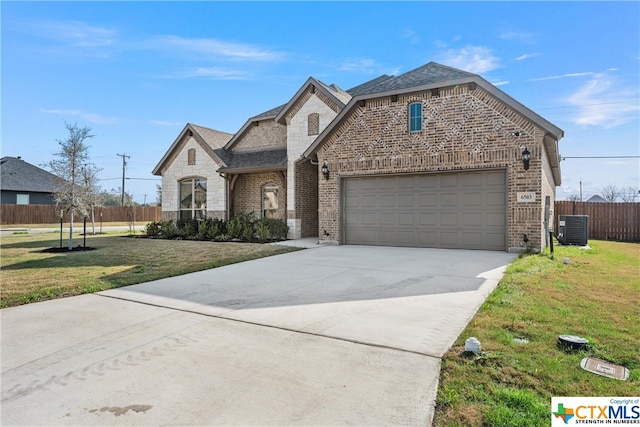 french country inspired facade featuring a front lawn and central AC unit