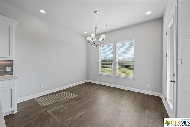 unfurnished dining area featuring dark hardwood / wood-style floors and a notable chandelier