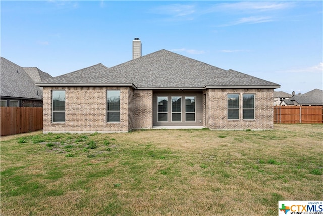 rear view of property with a yard