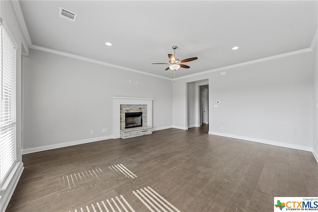 unfurnished living room featuring ornamental molding, ceiling fan, a stone fireplace, and dark hardwood / wood-style floors