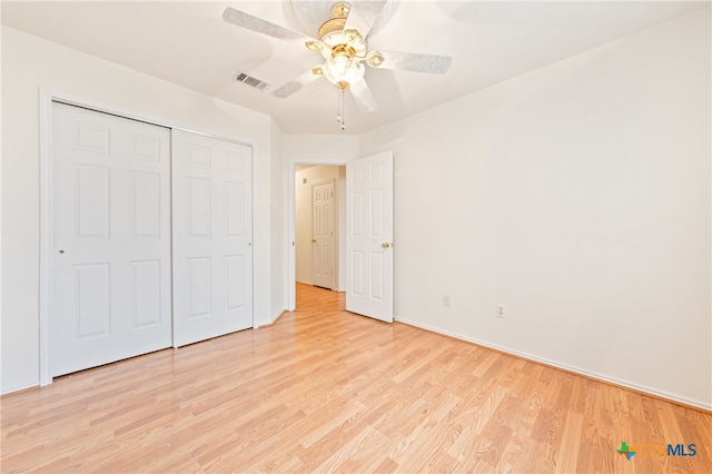 unfurnished bedroom with ceiling fan, a closet, and light wood-type flooring