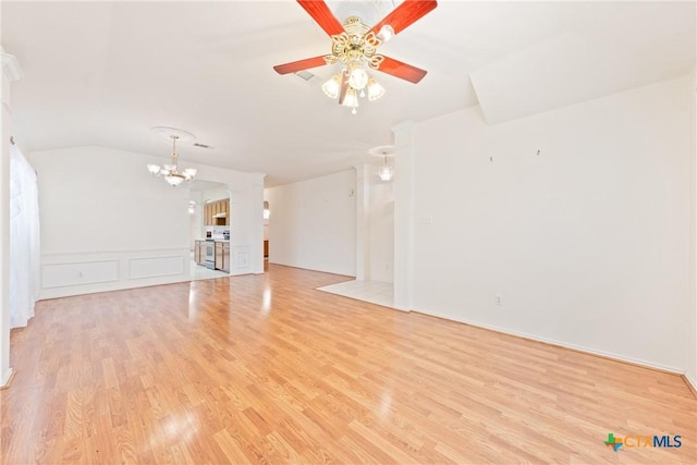 unfurnished living room featuring ceiling fan with notable chandelier, light hardwood / wood-style flooring, and vaulted ceiling