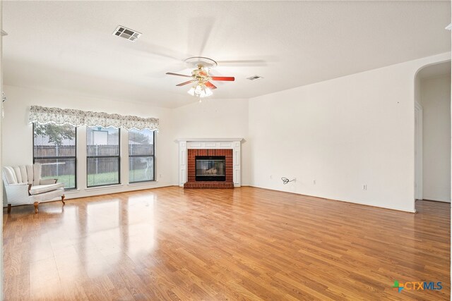 unfurnished living room featuring ceiling fan, a fireplace, and wood-type flooring